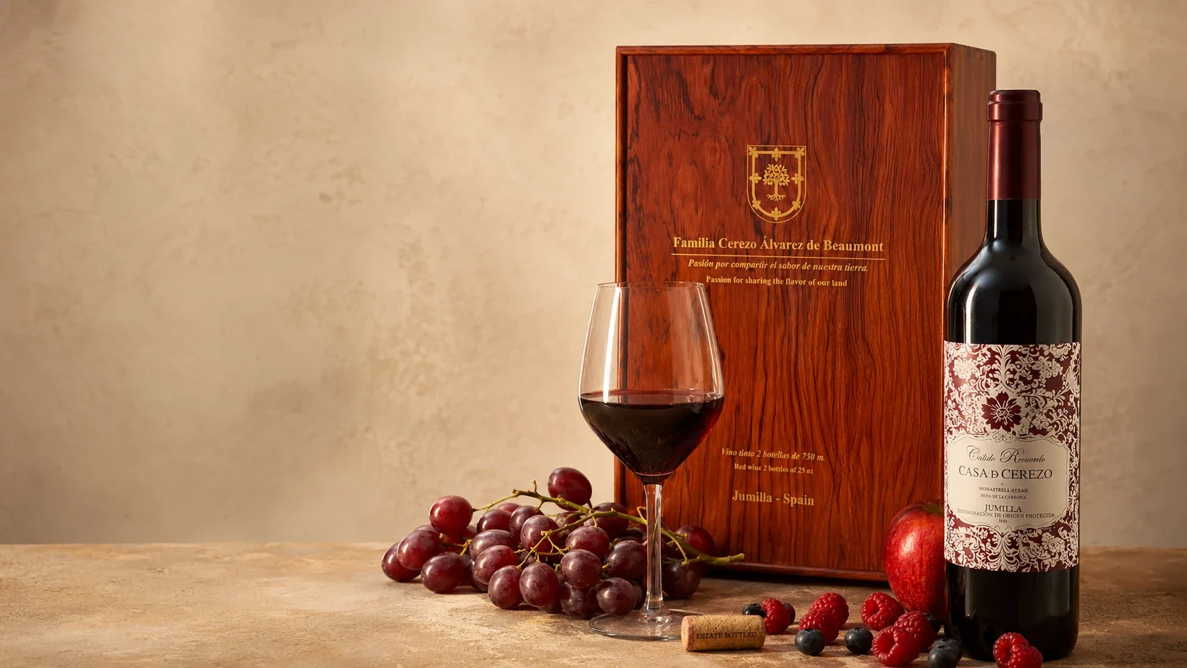 Botella de vino Casa de Cerezo con caja de madera, copa y uvas sobre fondo cálido mediterráneo