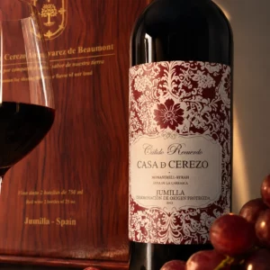 Detalle de la etiqueta de la botella Casa de Cerezo junto a caja de madera y uvas